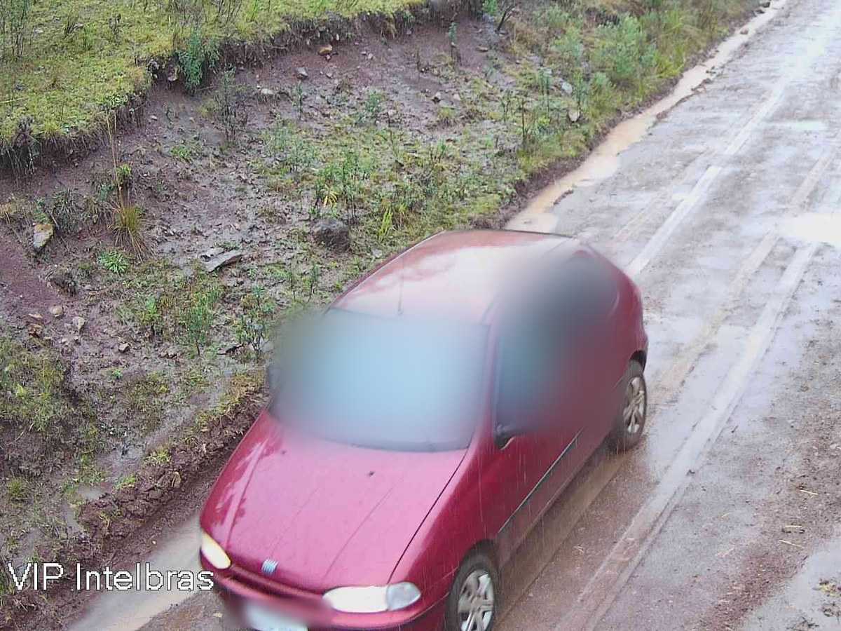 Carro vermelho em estrada de terra molhada, com a moldura “Carro” marcada pela IA